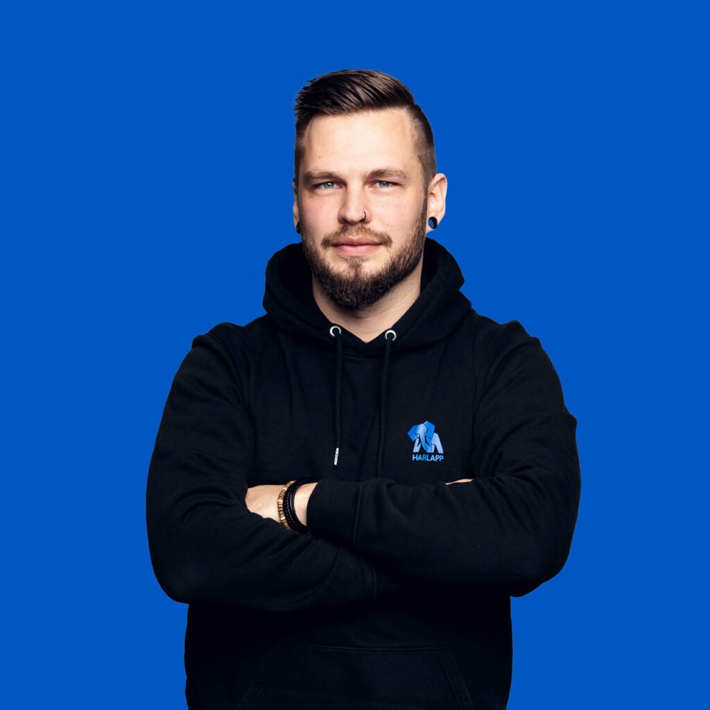 Lead-Developer Alexander Elert lächelt mit verschränkten Armen in die Kamera