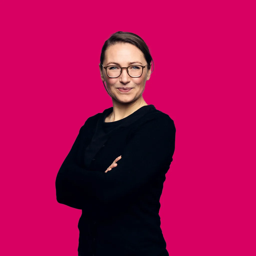 Projektmanagerin Angie Opalic lächelt mit verschränkten Armen in die Kamera