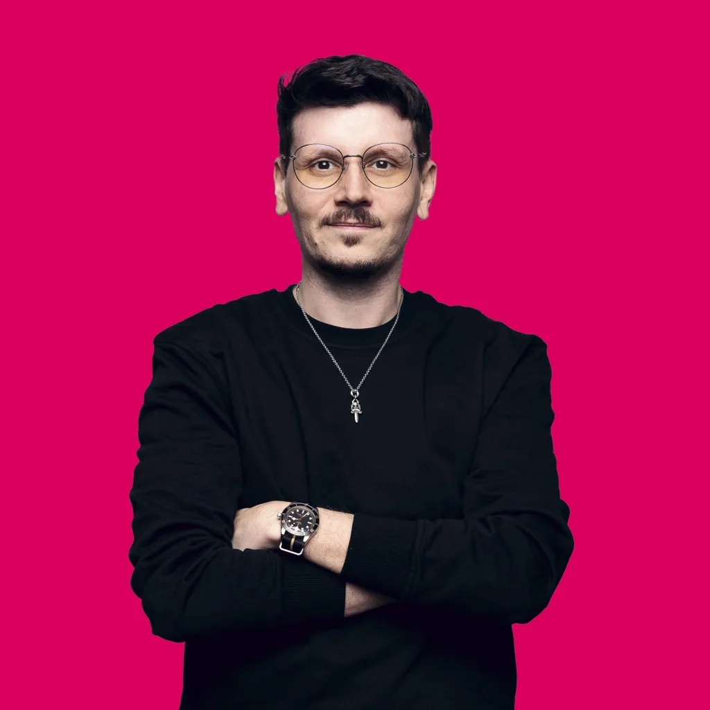 Full Stack Developer Bartosz Swiderski lächelt mit verschränkten Armen in die Kamera