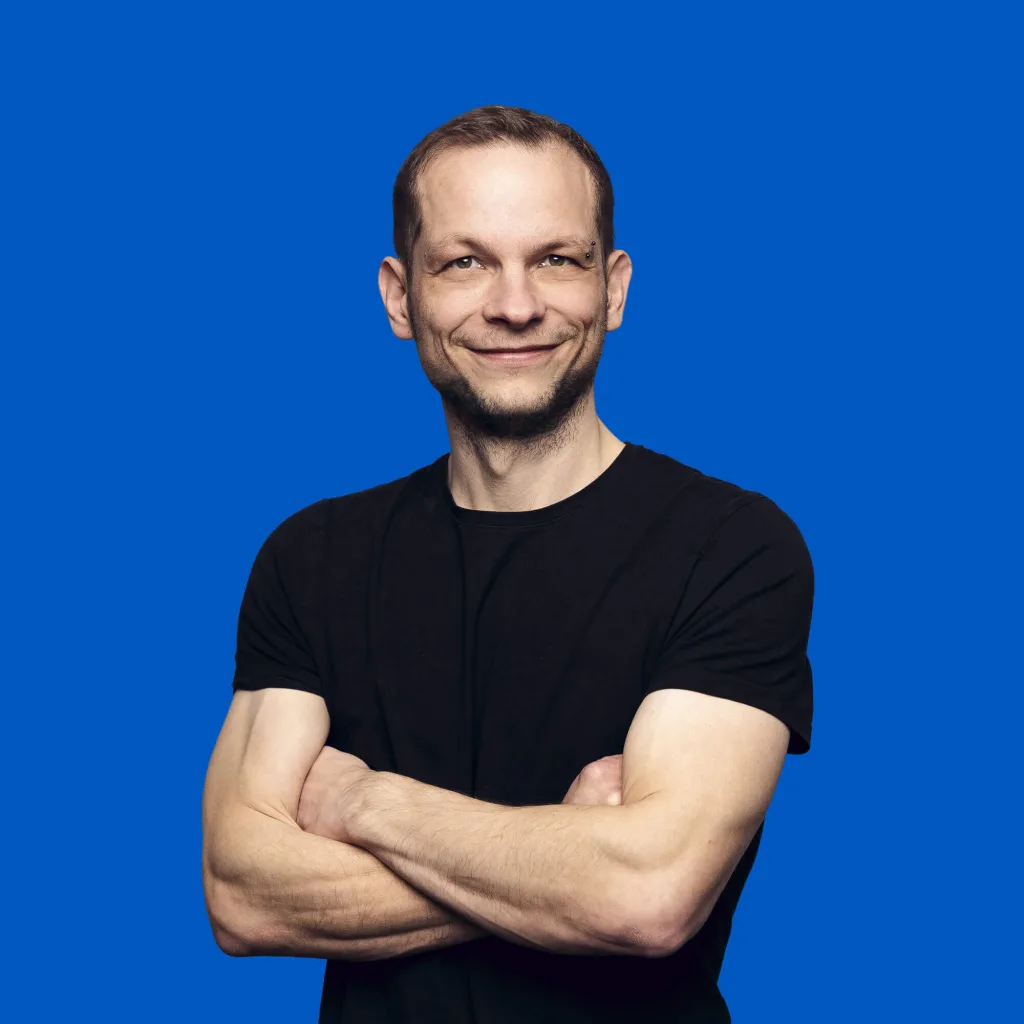 Data-Scientist Gunnar Tschöpke lächelt mit verschränkten Armen in die Kamera