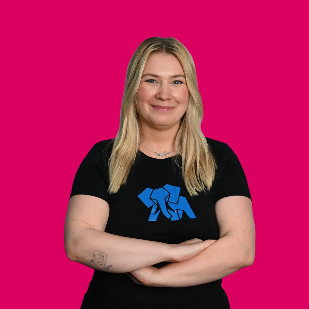 Frontend Entwicklerin Lilly Seiffert lächelt mit verschränkten Armen in die Kamera