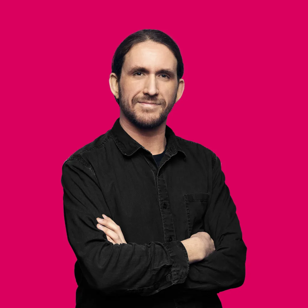 Full Stack Developer Malte-Maurice Dreyer lächelt mit verschränkten Armen in die Kamera