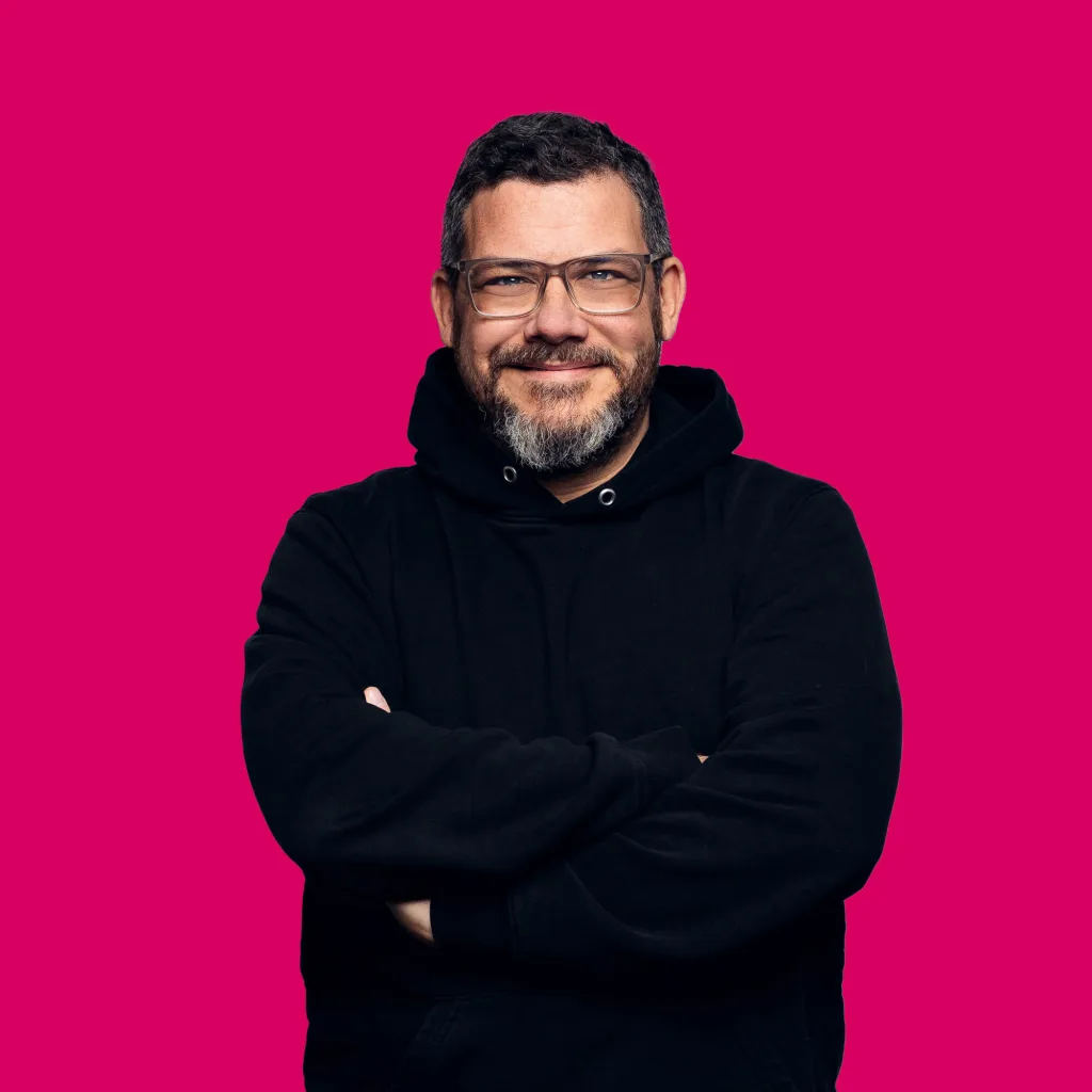 UX-Designer Martin de la Vega lächelt mit verschränkten Armen in die Kamera