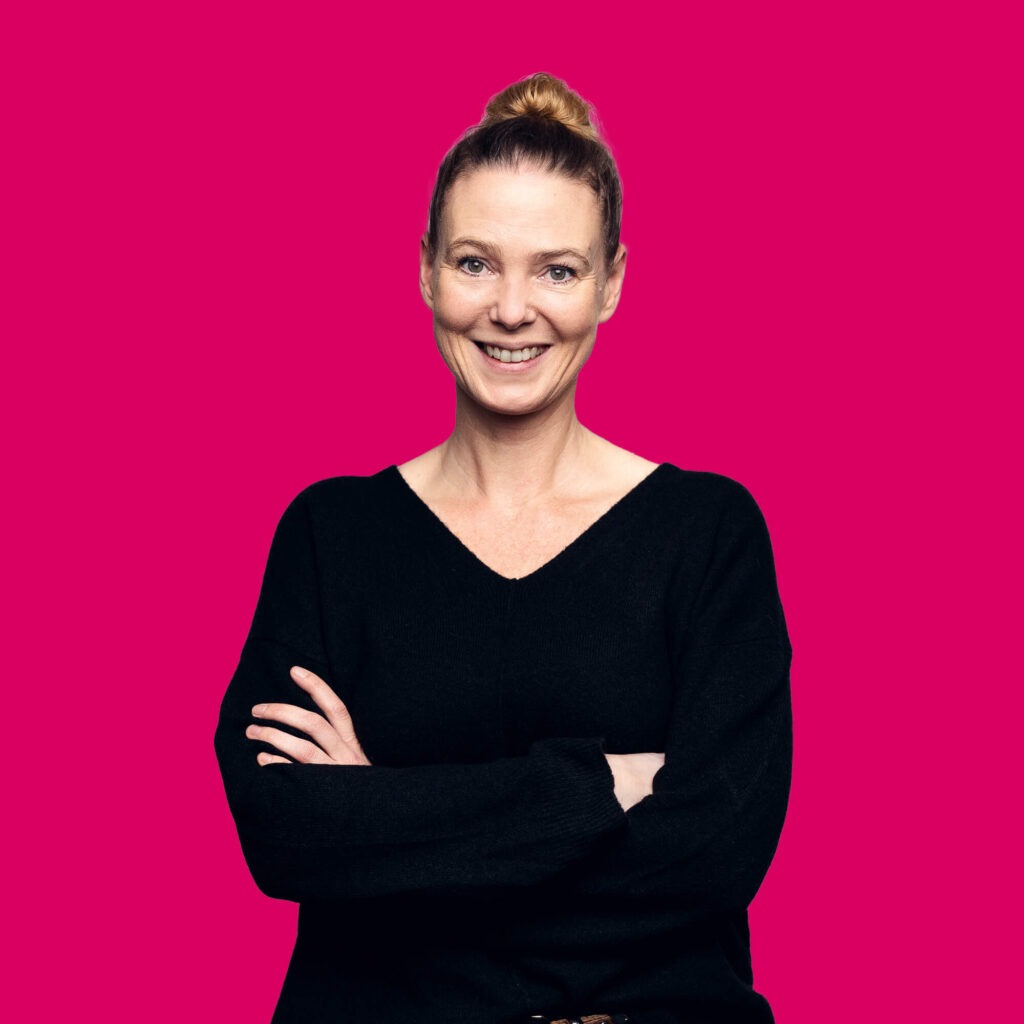 Art Directorin Susanne Schaschinger lächelt mit verschränkten Armen in die Kamera