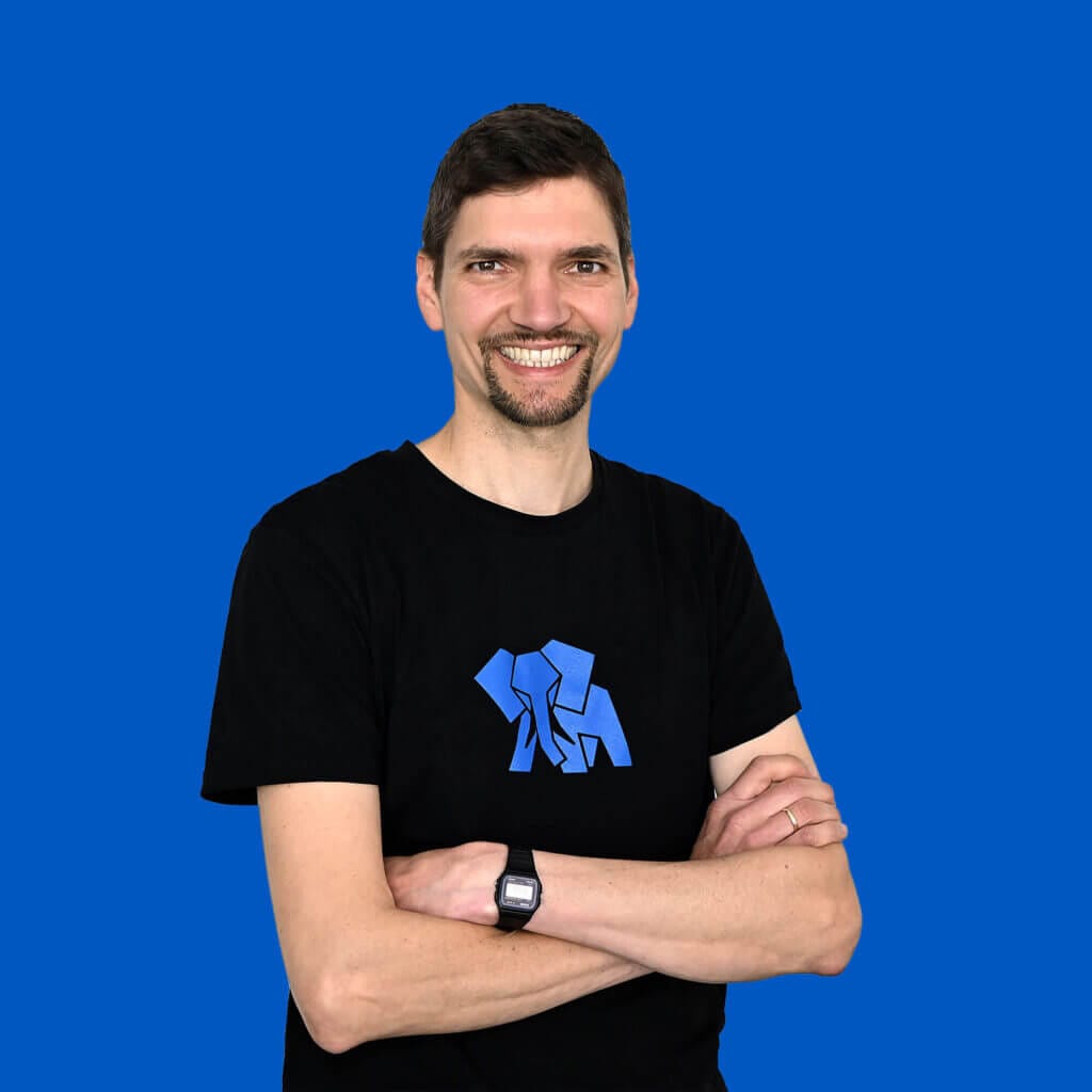 Infrastructure Administrator Florian Farnung lächelt mit verschränkten Armen in die Kamera