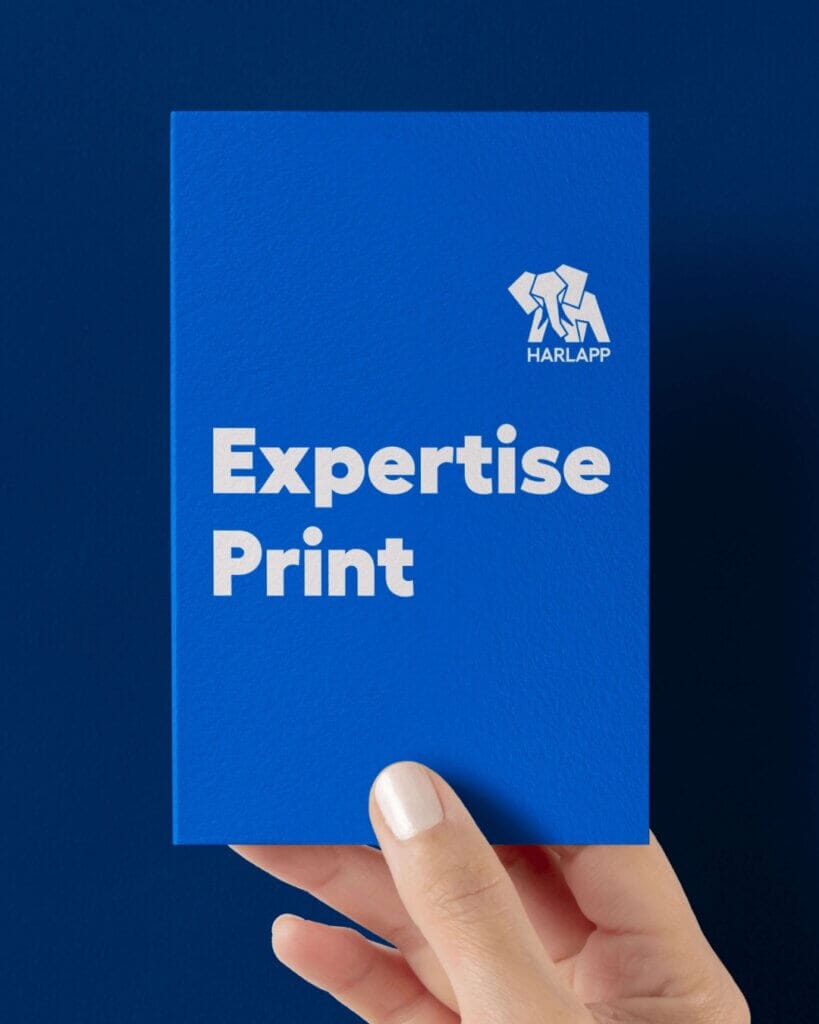 Eine Hand hält eine blaue Karte mit der weißen Aufschrift „Expertise Print“ und dem HARLAPP-Logo.